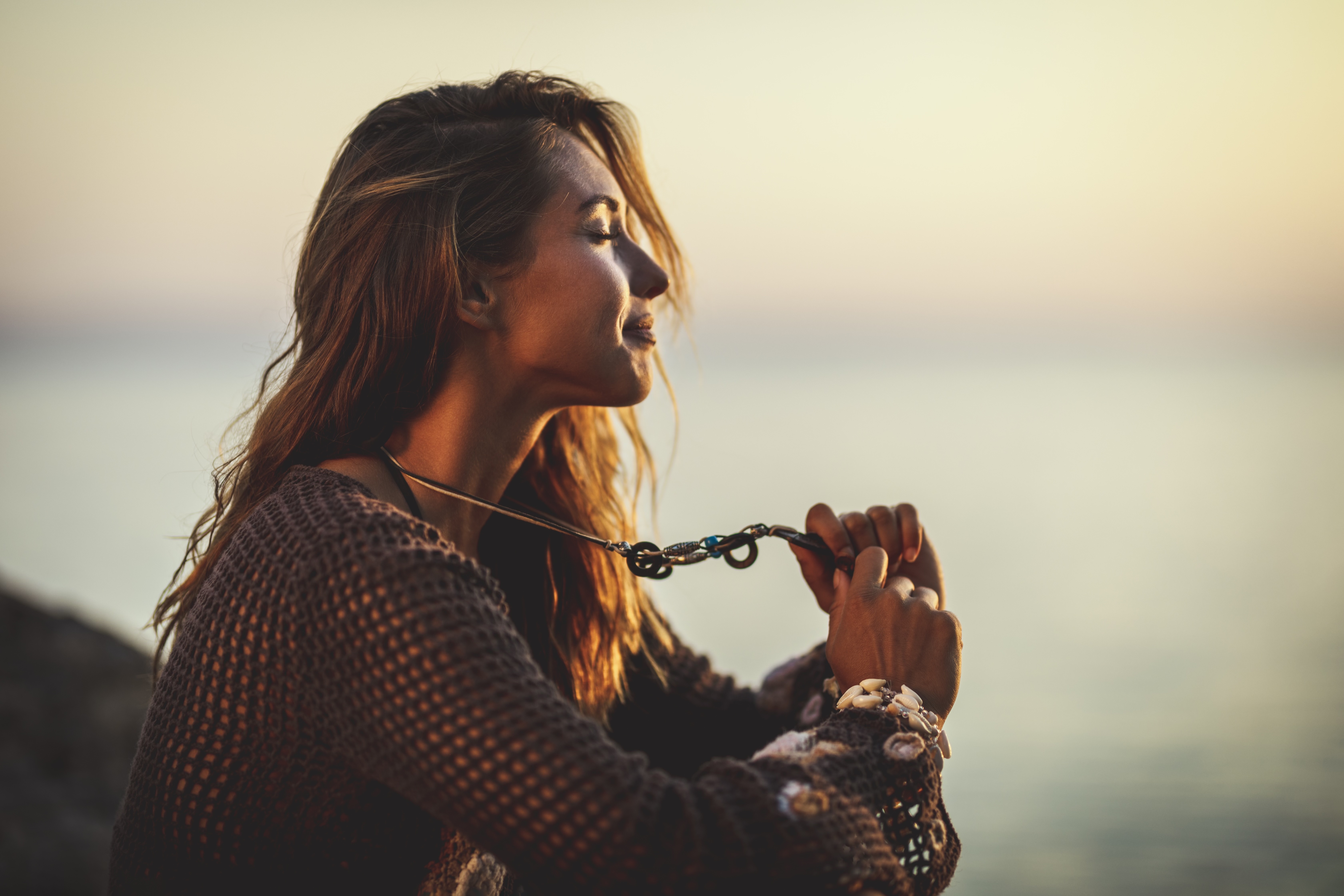 Woman in peaceful reflection by the ocean